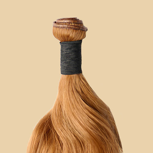 Blonde hair extensions with a black band on a beige background